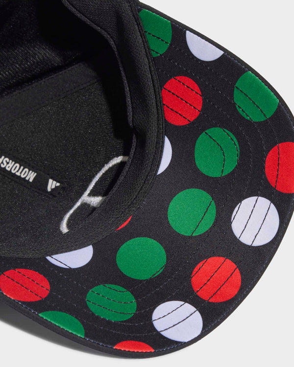 Close-up of the black Monza driver cap showing its patterned brim with red, green and white circles.