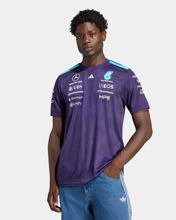 A model wearing the Mercedes-AMG Petronas F1 purple Vanda Bloom driver tee with sponsor logos.